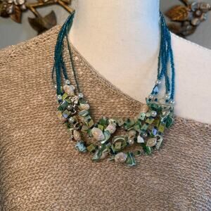 Multi strand statement necklace featuring teal Shells